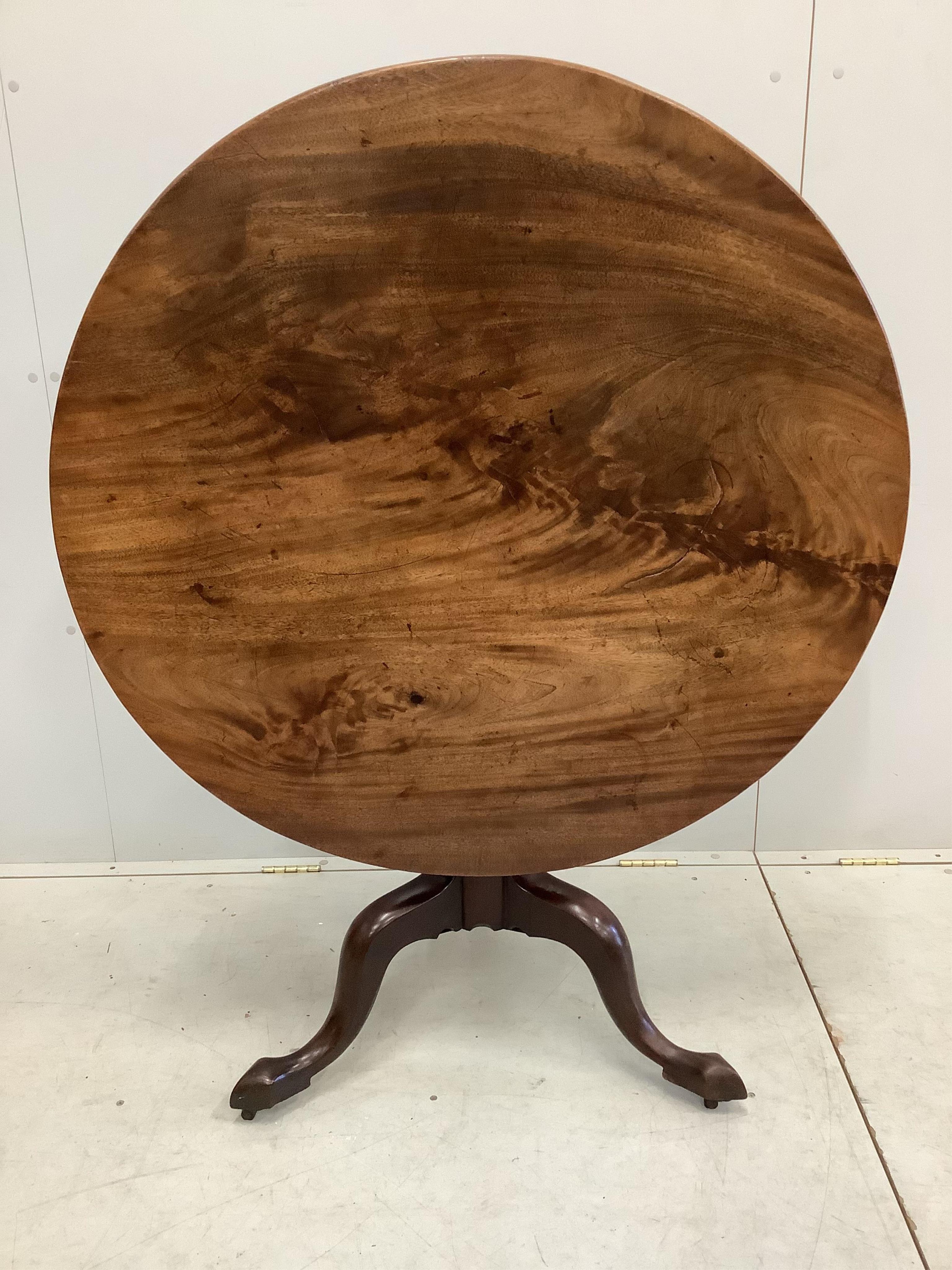 A George III circular mahogany tilt top tripod tea table, diameter 99cm, height 75cm together with four George III mahogany dining chairs. Condition - fair